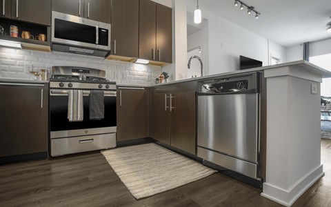 A modern kitchen with a stainless steel refrigerator and oven.