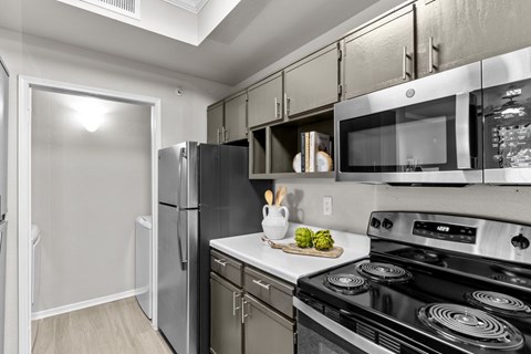 A kitchen with a black stove top oven and a black refrigerator.
