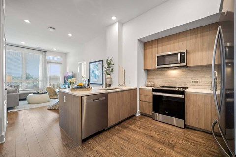 A modern kitchen with wooden cabinets and stainless steel appliances.