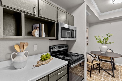 A kitchen with a stove top oven and a microwave above it.