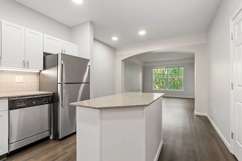 A kitchen with white cabinets and a granite countertop.