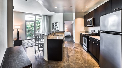 a kitchen and living room with a refrigerator and a sink