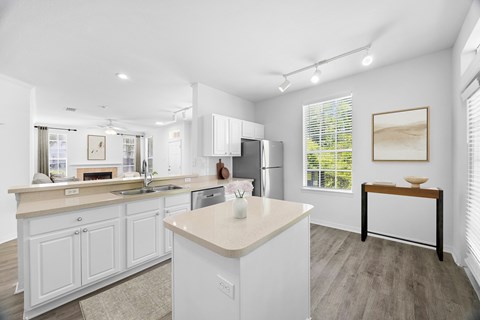A kitchen with white cabinets and a large island.