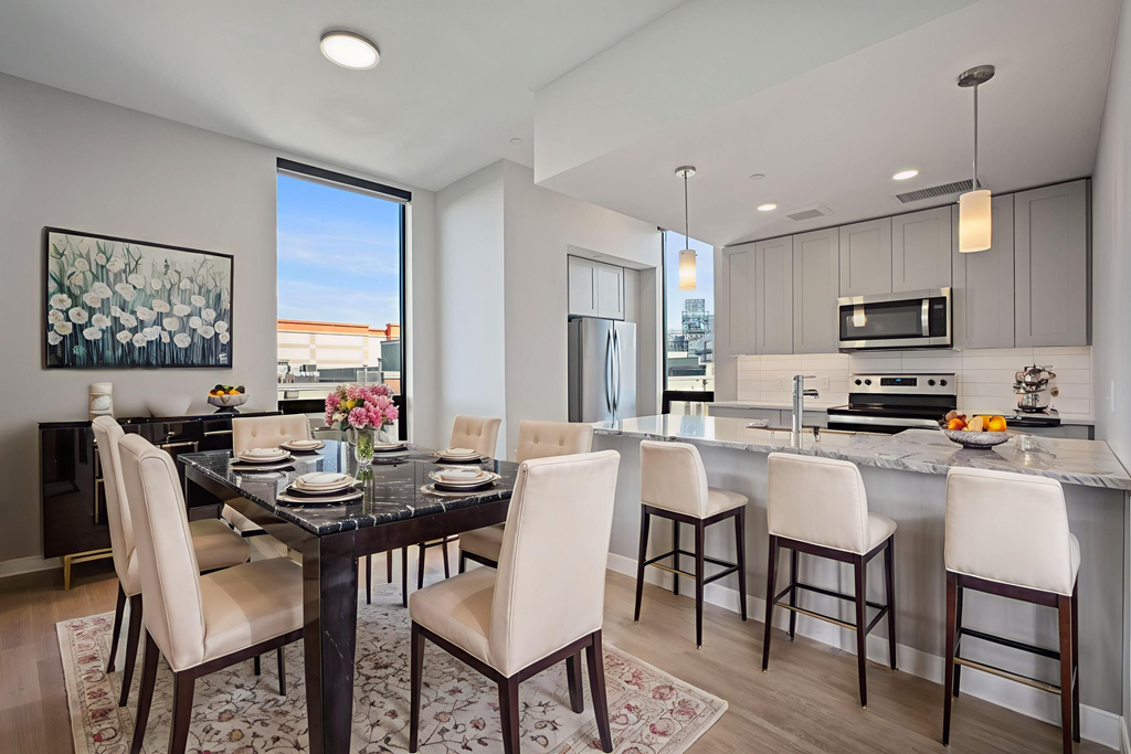 A modern dining room with a black table and white chairs.
