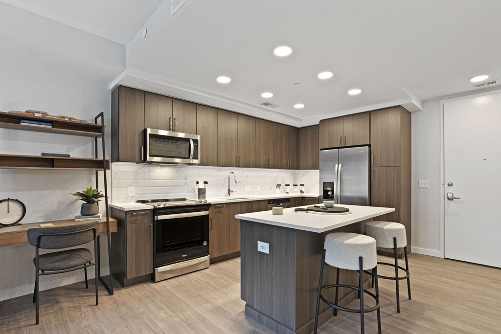 a kitchen with a large island with three stools