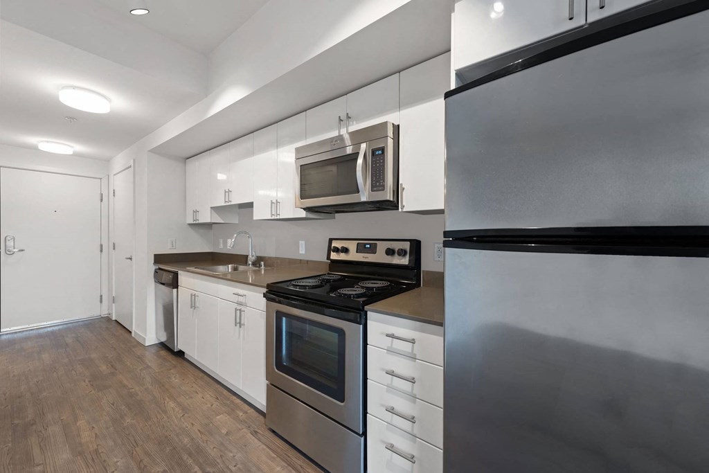 A modern kitchen with stainless steel appliances and white cabinets.