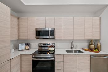 Modern kitchen with wood cabinets and stainless steel appliances at Windsor Ludlam Trail in Miami, FL.