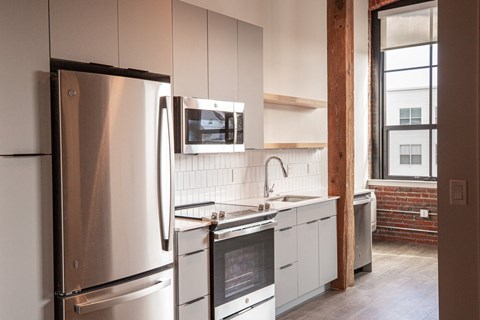 a kitchen with white cabinets and a stainless steel refrigerator