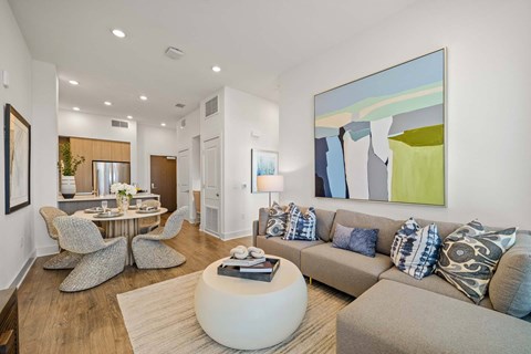 A modern living room with a large abstract painting on the wall.