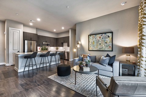 a living room and kitchen with a couch and a table