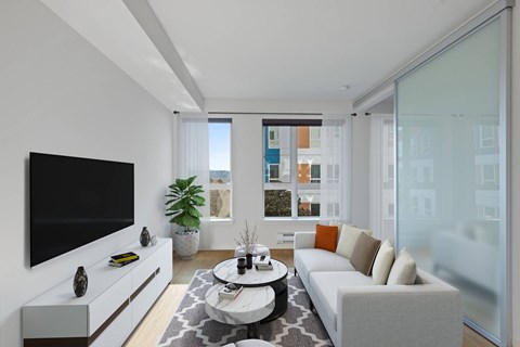 A modern living room with a white couch and a flat screen TV.