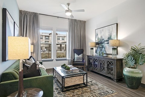 an apartment living room with a green couch and a window