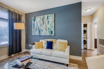 a living room with a couch and a table in front of a wall with a painting