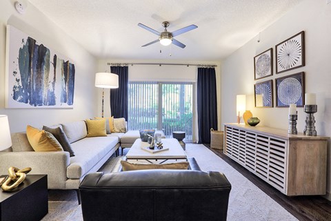 a living room with a couch and a ceiling fan