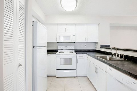a white kitchen with white appliances and white cabinets
