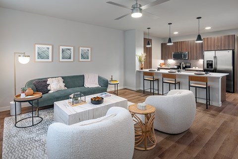 a living room and kitchen with a couch and chairs