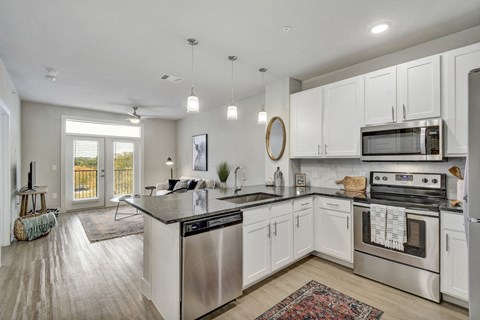 an open kitchen with stainless steel appliances and white cabinets