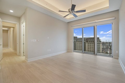 a living room with a ceiling fan and a balcony