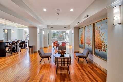 a living room with a table and chairs and a large painting on the wall