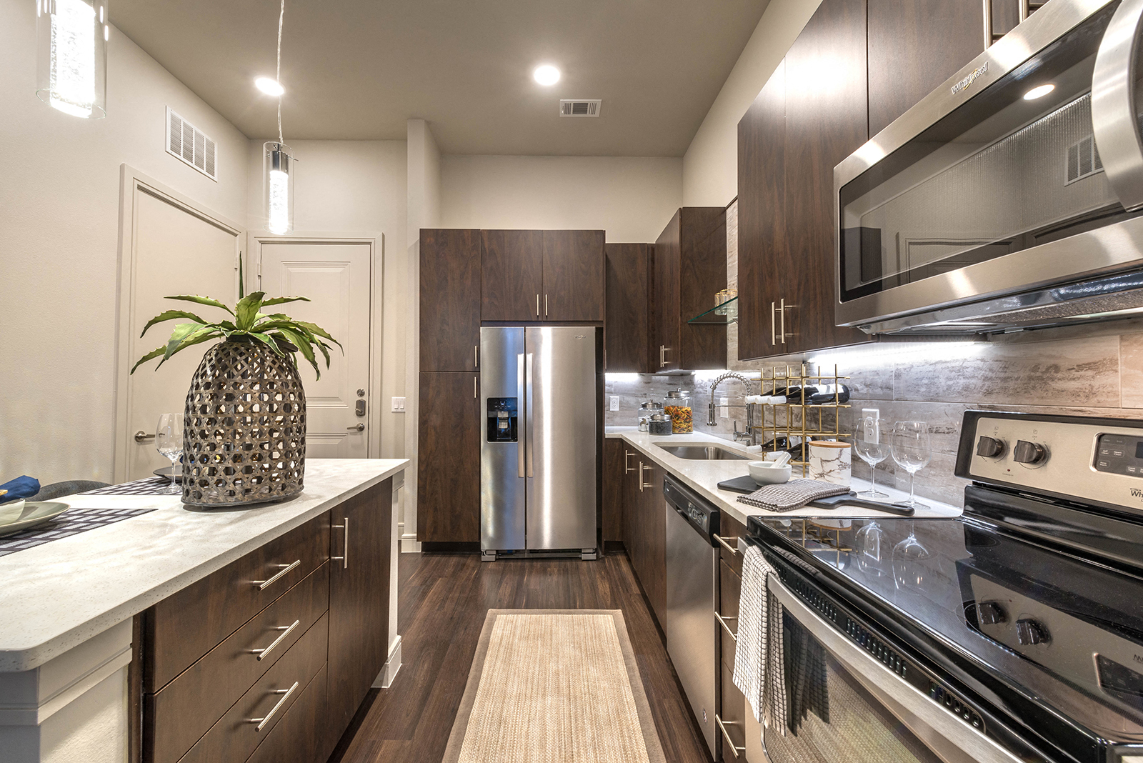 a kitchen with stainless steel appliances and marble counter tops