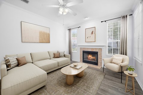 A living room with a fireplace, a couch, a chair, and a painting on the wall.