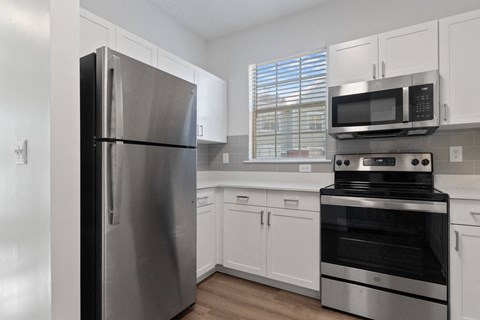 a kitchen with stainless steel appliances and white cabinets