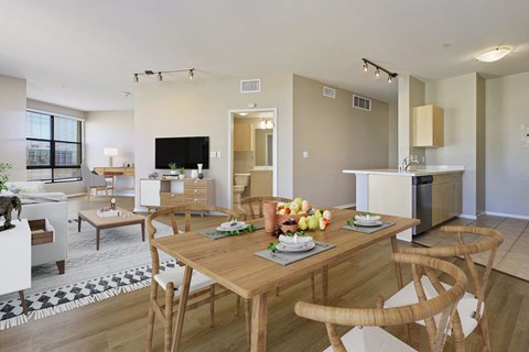 a living room and dining room with a wooden table and chairs