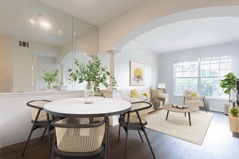 a living room and dining room with a round table and chairs