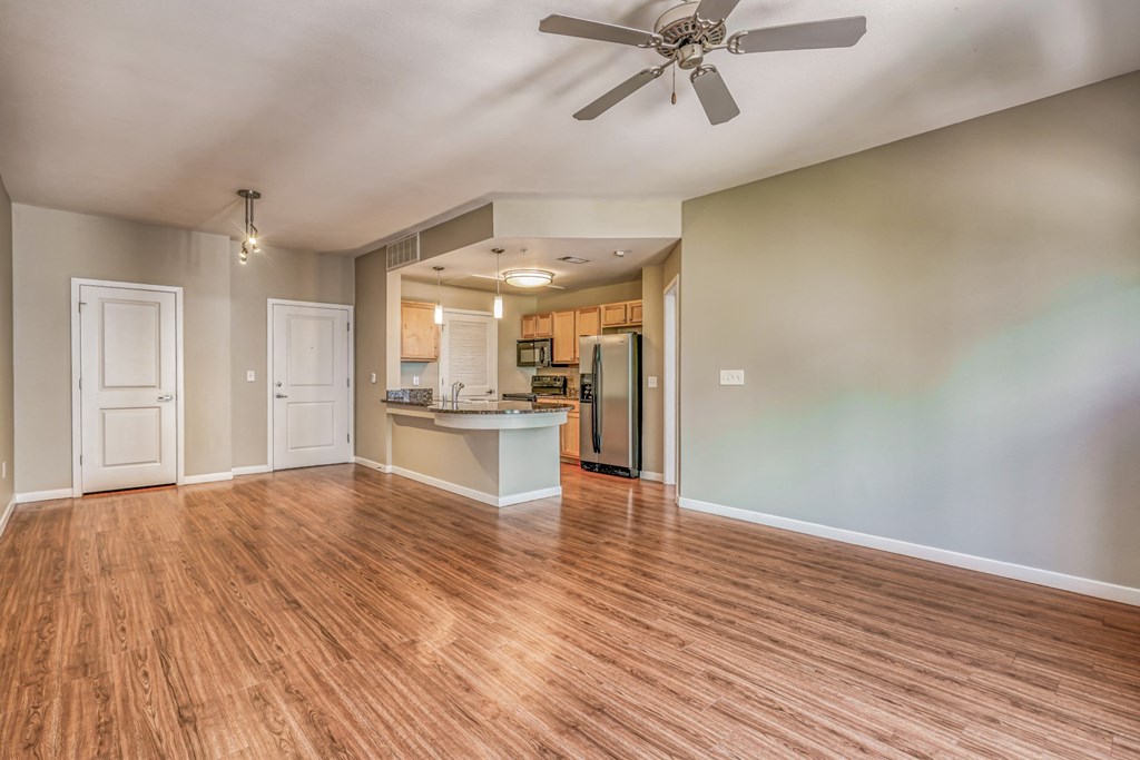 A living and kitchen area with a ceiling fan and hardwood floors at The District, Denver, CO