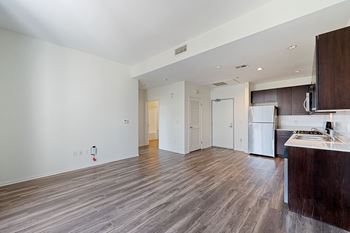 a bedroom with a medium sized bed and a kitchen with a stove and refrigerator