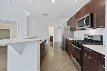a kitchen with white countertops and wooden cabinets