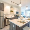 a kitchen with a large window and a sink and a refrigerator