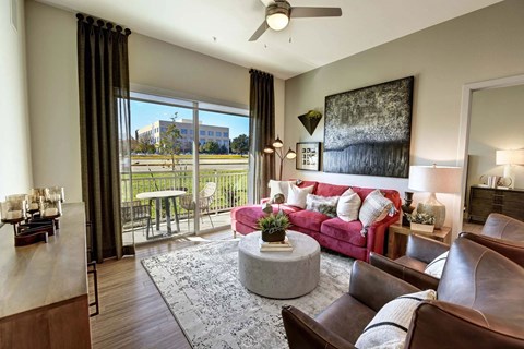 a living room with a pink couch and a sliding glass door