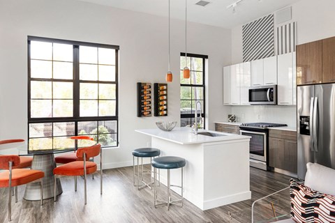 a kitchen with a large island and a table with four stools