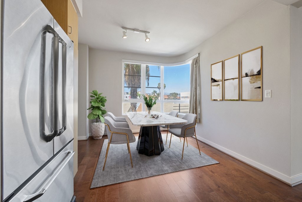 Ample space to work remotely, relax with a book or entertain. a dining room with a table and chairs and a window