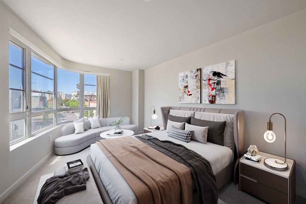 Expansive bedrooms that can fit a king-size bed a bedroom with a bed and a couch and a large window