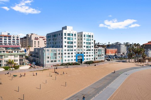 A beachfront with a large building in the middle of the beach.