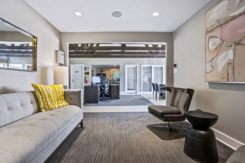 a living room with a couch and a chair and a kitchen