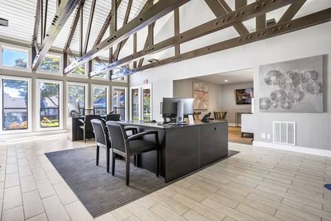 a dining room with a desk and chairs in a room with large windows