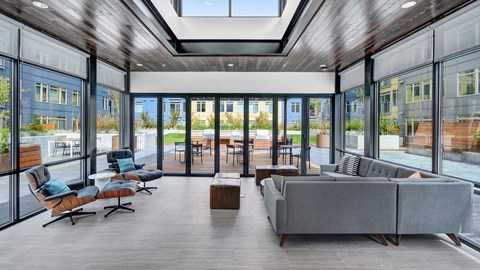 a living room with couches and chairs and glass doors