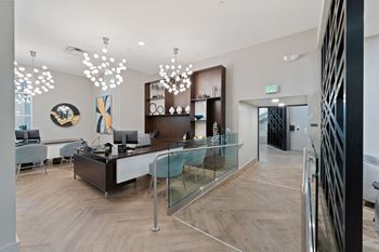 an office with a glass desk and chairs and a hallway with a staircase
