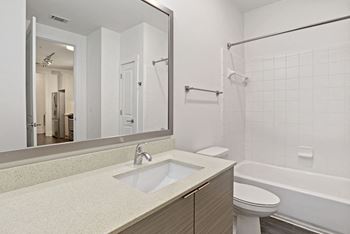A bathroom with a mirror and a toilet and a sink