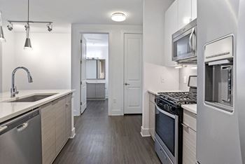 an empty kitchen with stainless steel appliances and a sink