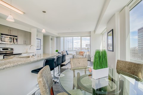 an open kitchen and living room with a glass table and chairs