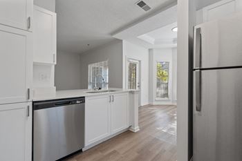 a renovated kitchen with white cabinets and stainless steel appliances