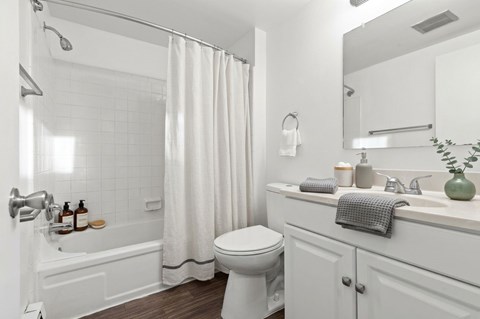 A white bathroom with a toilet, sink, and bathtub.