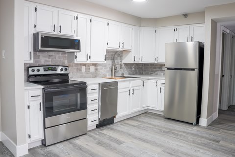 A kitchen with white cabinets and stainless steel appliances.