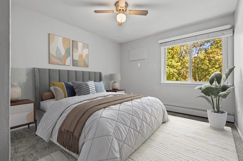 A bedroom with a large bed and a ceiling fan.