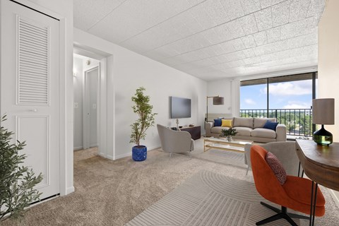 A living room with a white couch, a red chair, and a television.