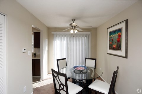 A dining room with a glass table and chairs.